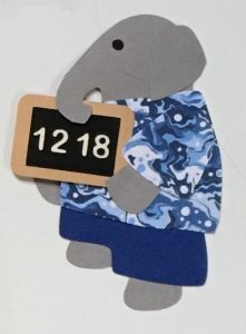 N for numbers, Elephant holding a chalkboard slate with the numbers "1218"