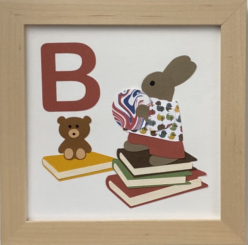 B initial sign - a rabbit with books, a toy bear, and a ball
